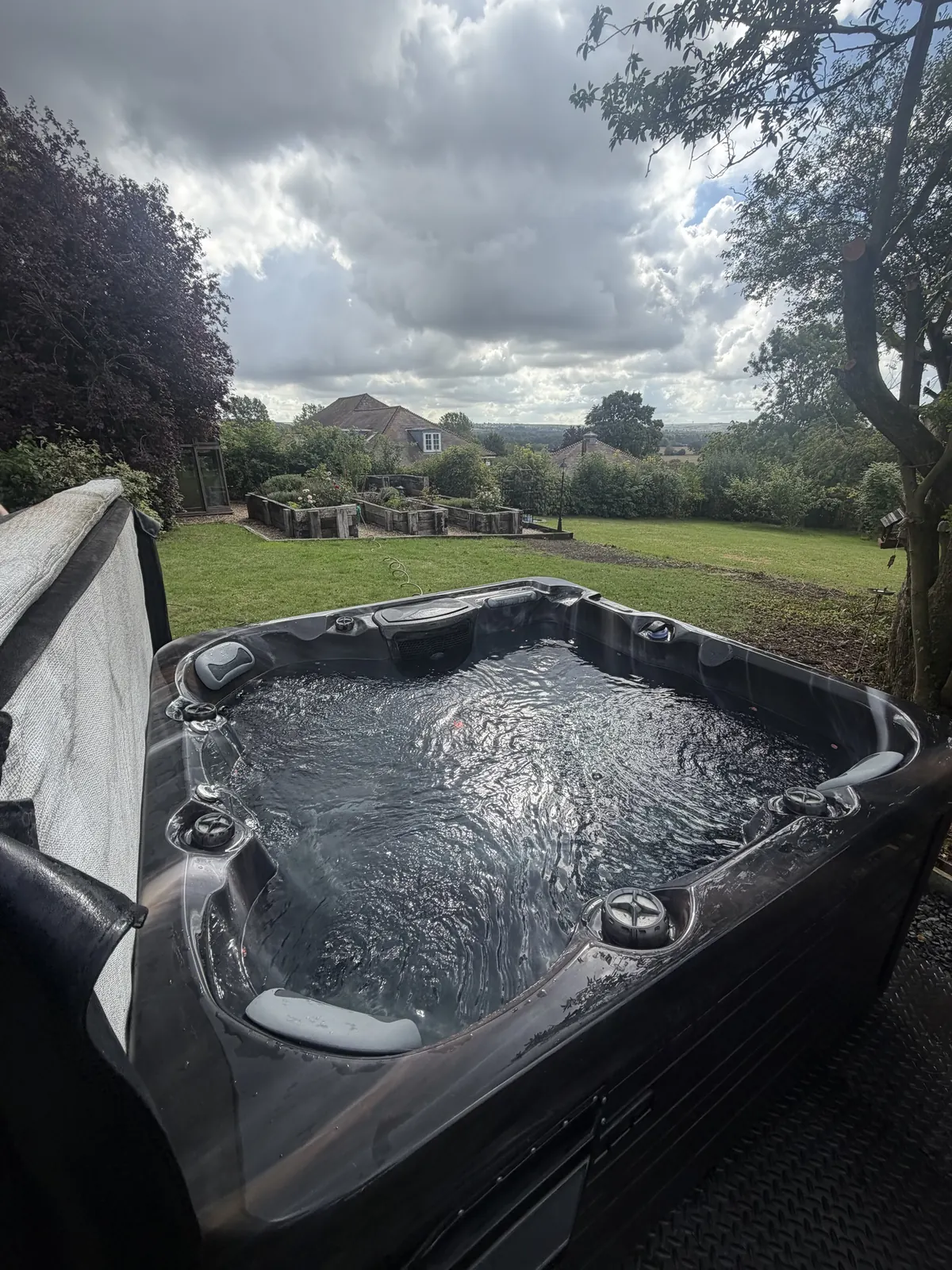 Hot tub installed on a gravel and grid base in a garden
