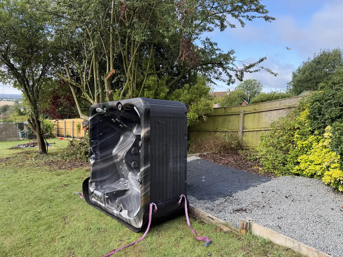 Hot tub delivered to the prepared base at the bottom of a garden