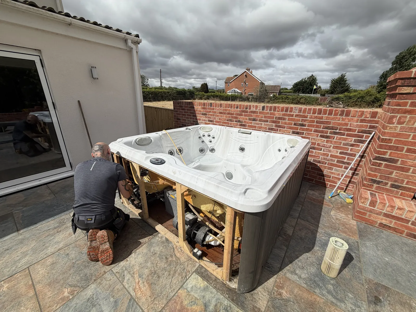 Hot tub service with the cabinet panels removed showing pumps and heater